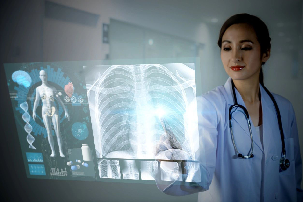 A doctor holding up an x-ray in front of him.